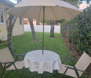 Ivory melrose tablecloth on a round table with umbrella