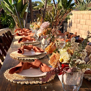 Knotted Panama linen napkins on plates with a center piece made of roses