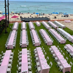 Pink tablecloths at a beach wedding. The wedding tablecloths are on 15 long rectangular tables. The table linen manufacturer is Premier Table Linens.