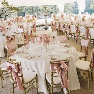 Round tablecloths on round tables at an outside wedding under a tent. 