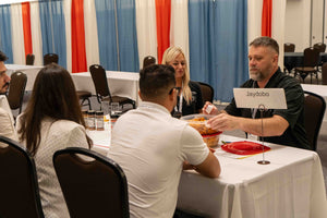 Trade shows attending a sampling booth. The booth has a white blank tablecloth.