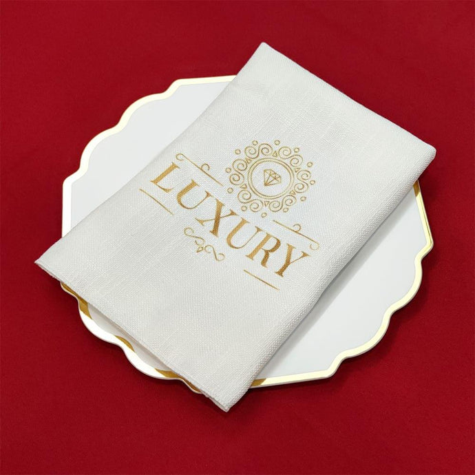Custom printed Panama napkin with gold logo folded on top of the plate with golden trim