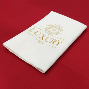 Custom Panama napkin with logo printed in gold on red tablecloth