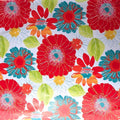 Round fitted oilcloth tablecloth with elastic, print is a colorful floral pattern on a white background
