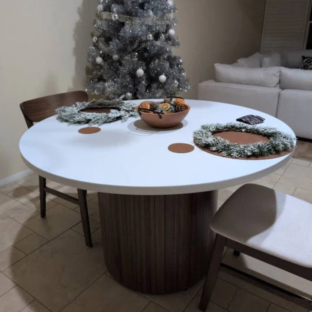 Round white fitted  tablecloth  with elastic decorative items in a room with a Christmas tree and wreath
