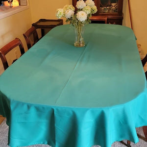 Turquoise oval tablecloth with a vase of flowers on the table