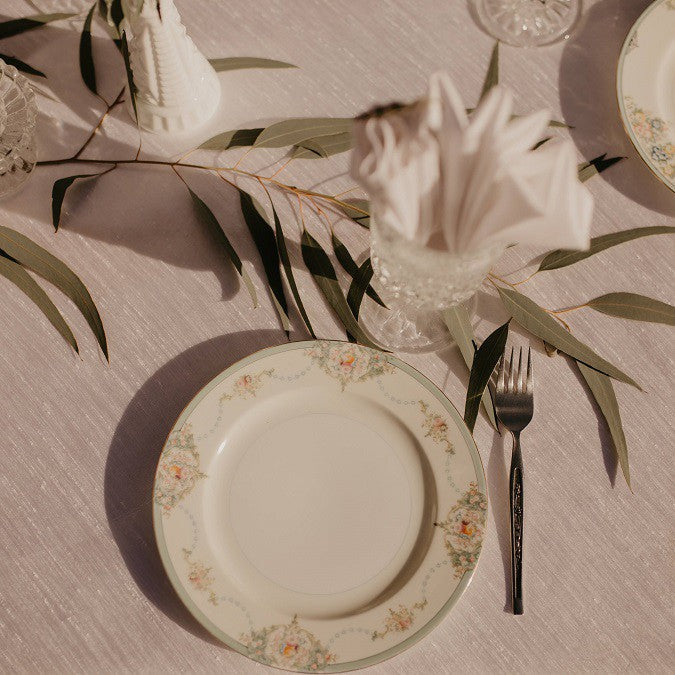 Ivory colored Majestic Linens shot from above with plates and napkins