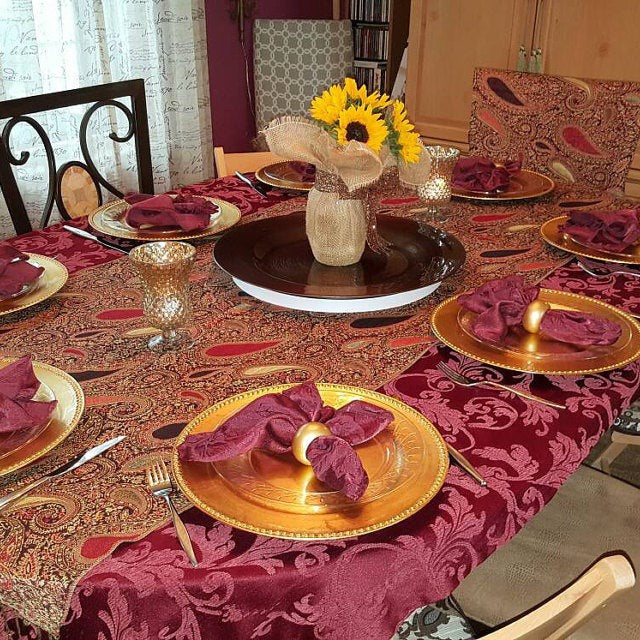 Burgundy-colored Melrose damask napkins folded into rings on a home dinner table