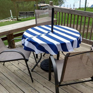 Nautical outdoor tablecloth with zipper for umbrella hole on a deck facing a pond