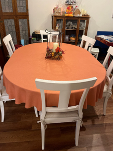 Oval burnt orange Table linens in a home dining room with a candle