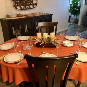 Orange oval tablecloth in a dining room decorated for autumn