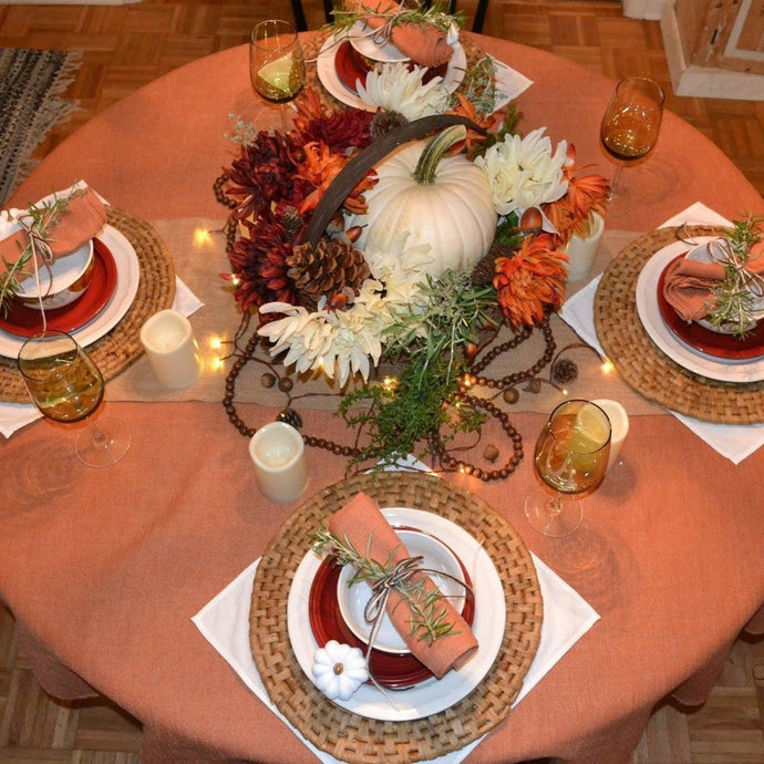 Spice round fall tablecloth tablescape with pumpkins, acorn and manyt harvest decorations, very formal table setting.
