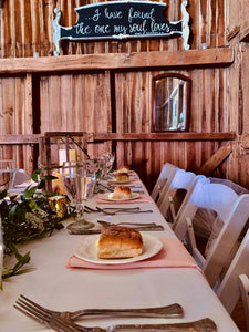 Peach-colored spun poly napkins at a barn style wedding table