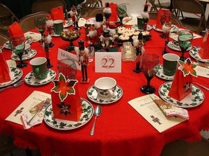 Round Holiday Red table cloth with place settings, table cards, and nutcrackers