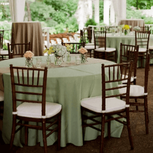 Ivory wedding linens in a semi-outdoor reception with flowers