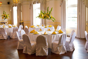Premium white linens with yellow napkins and flowers in a club-style setting