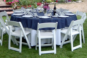 Outdoor dinner setting with layered poly premier tablecloths and a wine bottle.