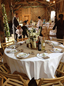 Barn wedding with white tablecloths and a burlap runner