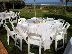 White Poly linens on the table for an outdoor reception by the water