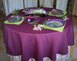 Fine linens layered on a round table with place settings