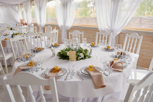 Lovely outdoor reception with wedding linens layered and peach napkins on top of the plates