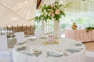 Beautiful Wedding linens on a round table with a tall floral arrangement and table number