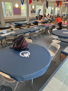 Round vinyl tablecloth with white logos at a middle school