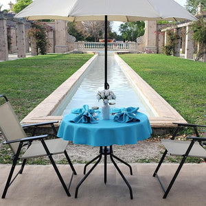Our Turquoise blue Panama table linen on a small round outdoor table with flowers by a pool