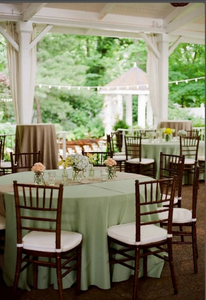 Classy wedding linens in the color sage with flowers at an outside reception