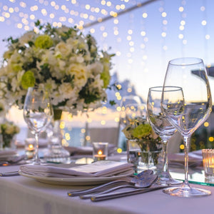 Outdoor evening reception with White linens and drinking glasses