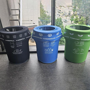 3 Recycling bins with our custom printed trash can covers in green, black and blue