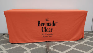 Branded fitted table cover for 6 foot table, orange cloth with black logo