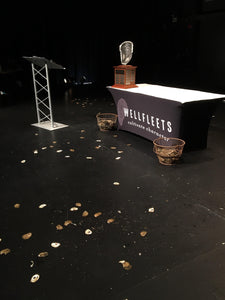 Black custom printed with logo Spandex tablecloth on a stage with an award and podium 