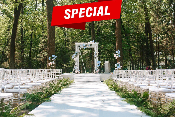 White wedding aisle runner leading up to ceremonial alter with arc and flowers in an outdoor setting