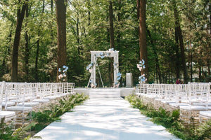 White wedding aisle runner at outdoor ceremony