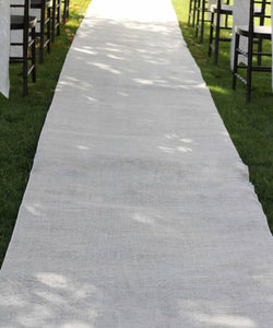 White burlap aisle runner at an outdoor wedding.