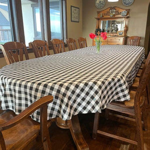 plaid tablecloth on a larg oval table with tulips on the table