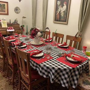 Black white checkered tablecloth with red placemats and cloth napkins during the holidays