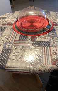 Round table with a table linen and a clear vinyl tablecloth on top