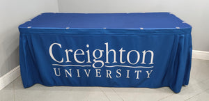 Custom printed table skirt with white letters on front panel and table topper on top
