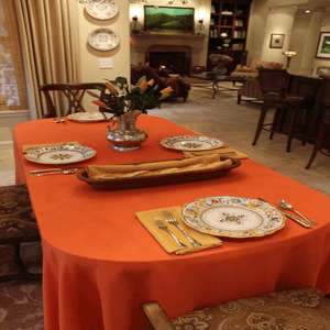 Orange tablecloth and Havana napkins on an oval tableL 