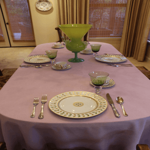Havana tablecloth with elegant china and silverwear on an oval table 