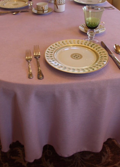 Pink oval tablecloth with fine china and glasses 