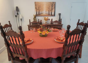 Fall tablecloth on an oval table, plates and fall napkins on the table