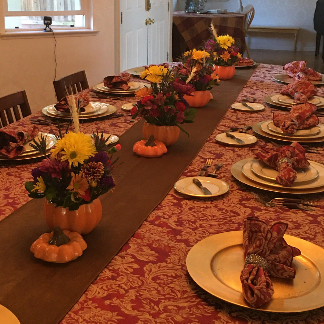 Fall tablecloth on an oval table, napkins and plates 