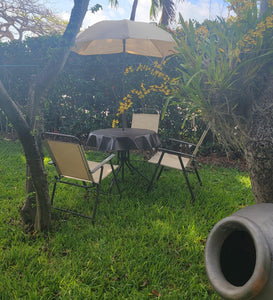 Black outdoor vinyl tablecloth with umbrella hole and zipper in a beautiful back yard