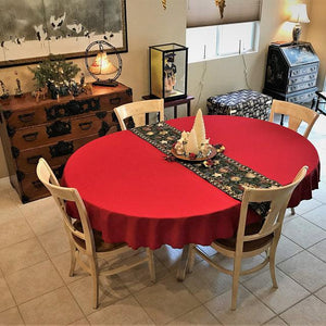 Holiday red tablecloth with Christmas decorations and table runner