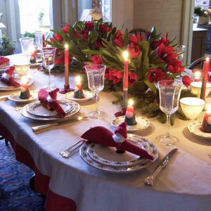 Christmas themed tablecloth on an oval table with decorations