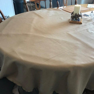 Ivory oval tablecloth with candle and wreath on the table