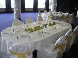 White custom tablecloth formally set with dishes and wine glasses